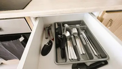 a drawer filled with utensils in a cabinet at Sunny 2BR Getaway Steps from the Beach with Wi-Fi in Larnaka