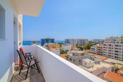 a balcony with two chairs and a view of the city at New Central 2 bedroom Apartment in Limassol