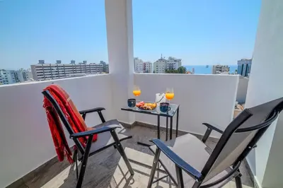 a balcony with two chairs and a table with fruit on it at New Central 2 bedroom Apartment in Limassol