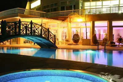 a swimming pool with a bridge in front of a building at Modern Smart-Home Studio Pools Gym Terrace View in Paralimni