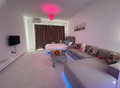 a living room with a couch and a table at Modern Smart-Home Studio Pools Gym Terrace View in Paralimni