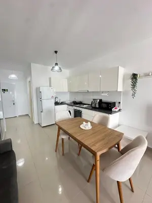 a kitchen with a wooden table and white appliances at Long Beach İskele - Caesar Resort Studio , Near Famagusta in Paralimni