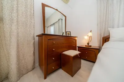 a bedroom with a dresser with a mirror and a bed at 3 bedroom flat central, beach, walking streets in Limassol