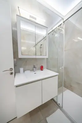 a white bathroom with a sink and a shower at 3 bedroom flat central, beach, walking streets in Limassol