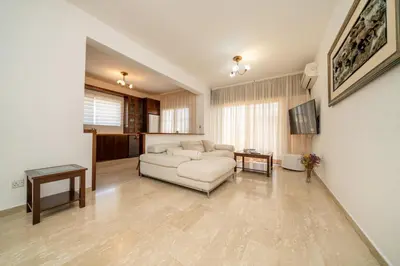 a living room with a white couch and a tv at 3 bedroom flat central, beach, walking streets in Limassol