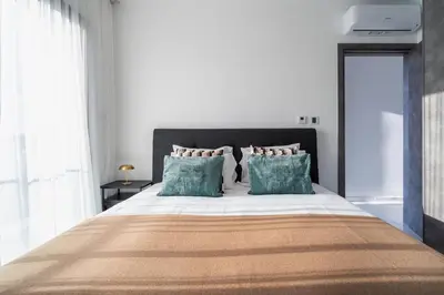 a bedroom with a large bed with blue pillows at Casino & Mall Luxury Jacuzzi Penthouse Suite in Limassol