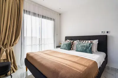 a bedroom with a large bed with a large window at Casino & Mall Luxury Jacuzzi Penthouse Suite in Limassol
