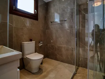 a bathroom with a toilet and a glass shower at Cyprus Sunbay Retreat in Ayia Napa