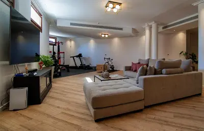 a living room with a couch and a flat screen tv at Cyprus Sunbay Retreat in Ayia Napa