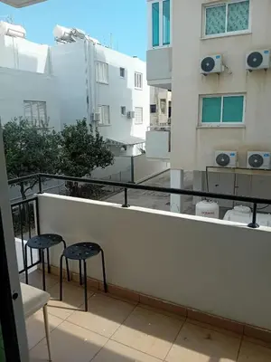 a balcony with two chairs and a view of a building at Smart 2 Bedroom Flat in Larnaka
