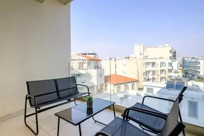 a balcony with a table and chairs and a view of a city at Downtown City View 2 Bedroom Apartment in Larnaka