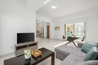 a living room with a couch and a tv at Downtown City View 2 Bedroom Apartment in Larnaka