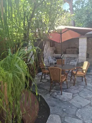 a patio with a table and chairs and an umbrella at Οίκος Λόφου-oikos Lofou in Lofou