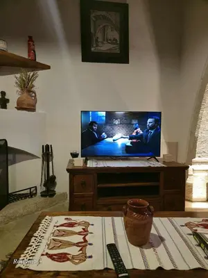 a living room with a flat screen tv on a table at Οίκος Λόφου-oikos Lofou in Lofou