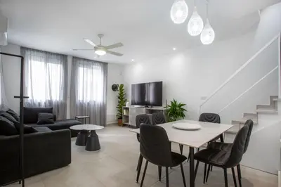 a white living room with a table and chairs at Two Bedroom House In Town Center by Sweet Keys in Limassol
