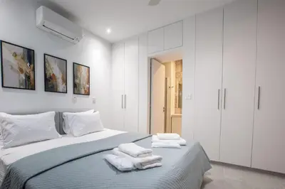 a white bedroom with towels on a bed at Two Bedroom House In Town Center by Sweet Keys in Limassol