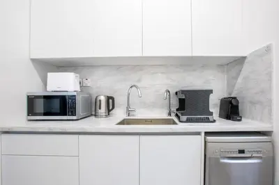 a white kitchen with a sink and a microwave at Two Bedroom House In Town Center by Sweet Keys in Limassol