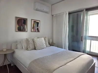 a white bedroom with a bed and a window at City Heart Residence by Staycom in Nicosia