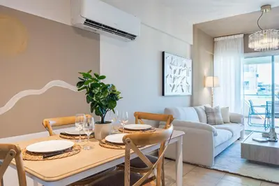 a dining room with a table and a couch at Calina - 3BR Apt W Pool & Balcony in Mackenzie in Larnaka