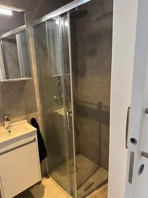 a shower with a glass door next to a sink at Modern Marvel Seaview in Paralimni