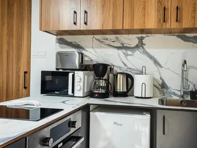 a kitchen with a microwave and appliances on a counter at Super Views Larnaca in Larnaka
