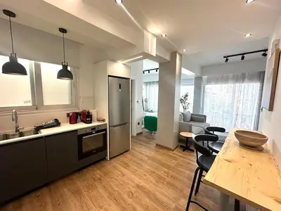 a kitchen and living room with a refrigerator and a table at Zeus Downtown Hub with Panoramic View in Nicosia