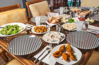 a table with plates of food on it at Kıbrıs Girnede 1 yatak odalı Süper lüks havuzlu daire in Vuda