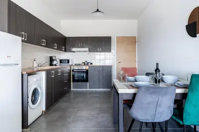 a kitchen with a table and a dishwasher at Sonic 2-Bedroom Apartment in Larnaka