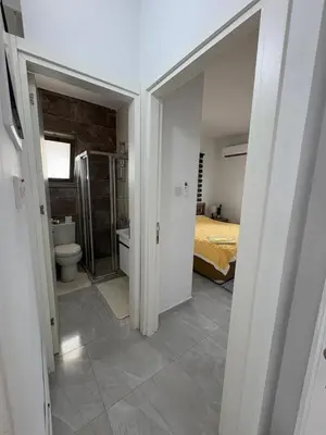 a bathroom with a toilet and a bed in a room at Lapta Yellow 1 bedroom in Limassol