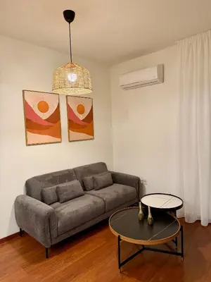 a living room with a couch and a table at Relax Beach Apartment in Larnaka