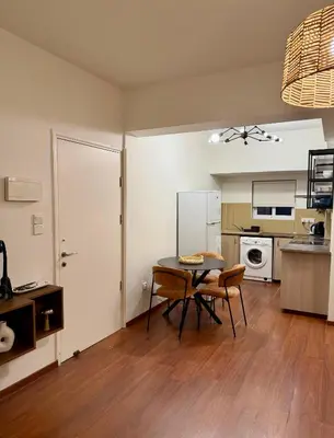 a kitchen with a table and chairs in a room at Relax Beach Apartment in Larnaka