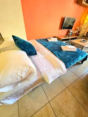 a large bed with blue sheets and pillows on it at Finikoudes Fabulous Apartment in Larnaka
