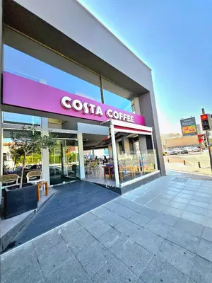 a costa coffee building with a sign on it at Finikoudes Fabulous Apartment in Larnaka