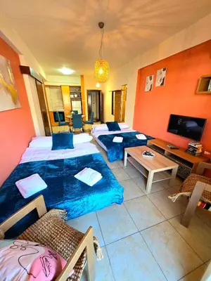 a large living room with two beds and a table at Finikoudes Fabulous Apartment in Larnaka