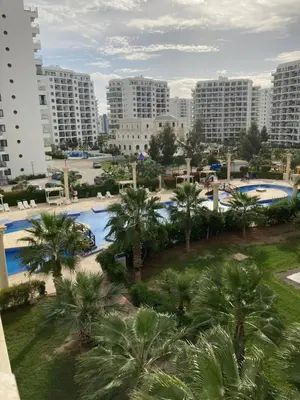 a view of a resort with palm trees and buildings at Квартира Апартаменты in Paralimni