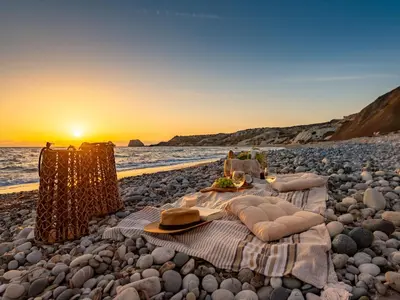 a picnic on a beach with the sun setting at Sanders Soul Apartments - Full Building in Limassol