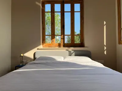 a bedroom with a white bed with a window at 1947 Rescued Stone House in Nicosia