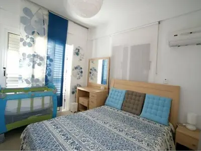 a bedroom with a blue bed in a room with windows at Villa Dione in Protaras