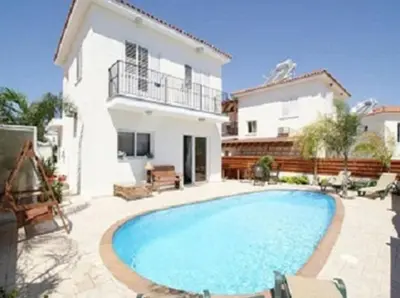 a villa with a swimming pool in front of a house at Villa Dione in Protaras