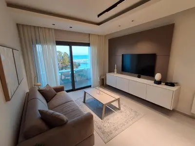 a living room with a couch and a flat screen tv at Lazuli Sea View & Pool Ap 502 in Larnaka