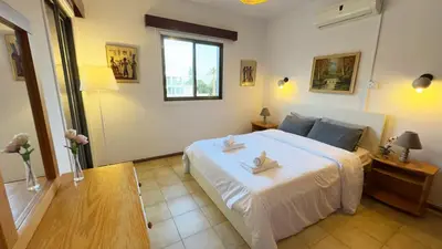 a bedroom with a white bed and a window at SundyBeach Beachfront 2Bdr Dhekelia in Larnaka