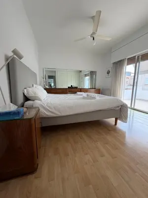 a bedroom with a large bed with a ceiling fan at Ellados in Strovolos