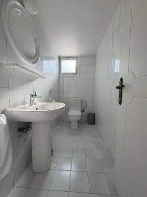 a white bathroom with a sink and a toilet at Ellados in Strovolos