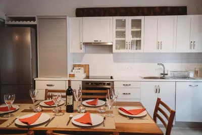 a kitchen with a wooden table with a bottle of wine at Hani Chrysomilou in Kalopanayiotis