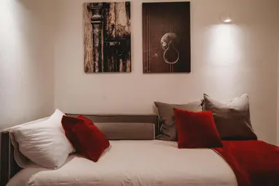 a bedroom with a bed with red and white pillows at Hani Chrysomilou in Kalopanayiotis