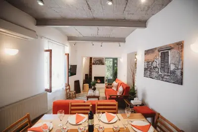 a restaurant with tables and chairs and a living room at Hani Chrysomilou in Kalopanayiotis