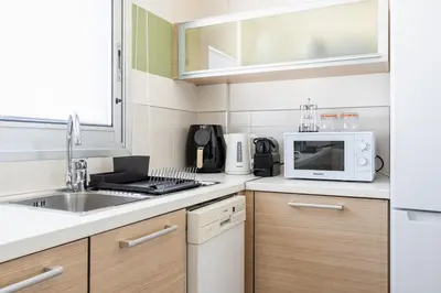 a small kitchen with a sink and a microwave at Local Host Living - Signature Apartments in Nicosia in Nicosia