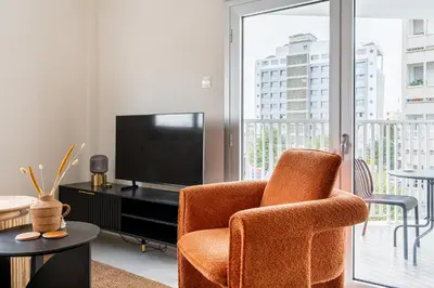 a living room with a chair and a television at Local Host Living - Signature Apartments in Nicosia in Nicosia