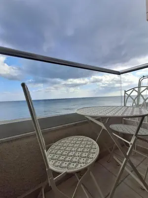 a table and chairs on a balcony with the ocean at Lazuli Sea View Beachfront Studio Nr 305 in Larnaka