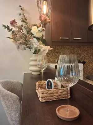a table with two wine glasses and a basket of flowers at Lazuli Sea View Beachfront Studio Nr 305 in Larnaka